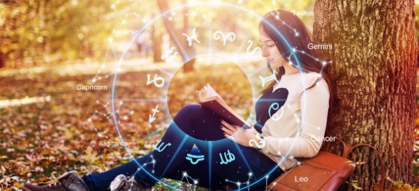 girl reading a book under a tree in the fall, with the signs of the zodiac superimposed