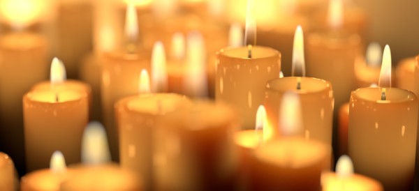 numerous white candles, all lit and glowing
