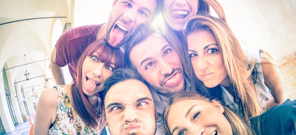 a group of friends taking a silly selfie outside