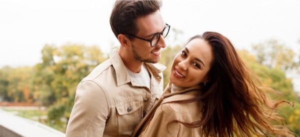 a happy couple spinning and smiling while being outdoors