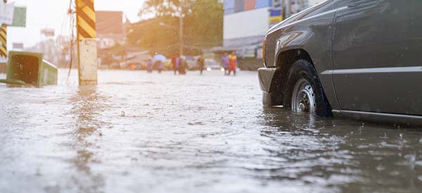 a car and people are shown in flooded water