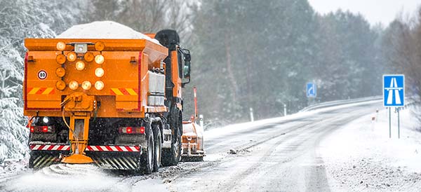 a truck maintains a snowy road